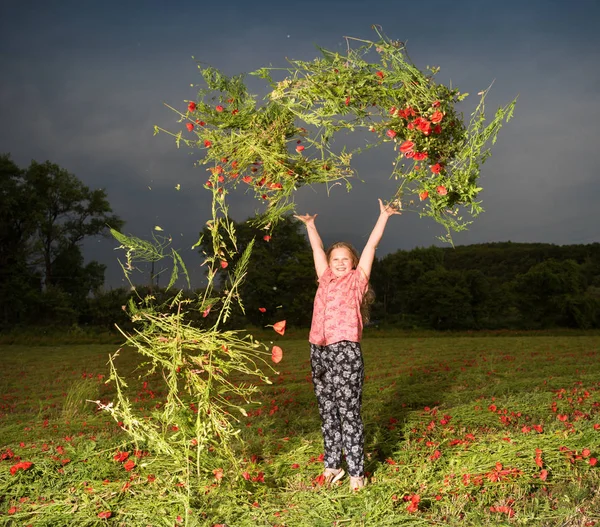 Улыбающаяся красивая девушка-подросток бросает маковые цветы — стоковое фото