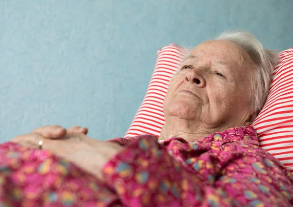 Παλιό άρρωστη γυναίκα ξαπλωμένη στο κρεβάτι — Φωτογραφία Αρχείου