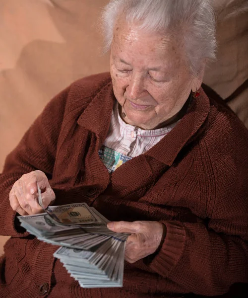Γκρίζα μαλλιά γριά κρατώντας Δολάριο μετρητά χρήματα — Φωτογραφία Αρχείου