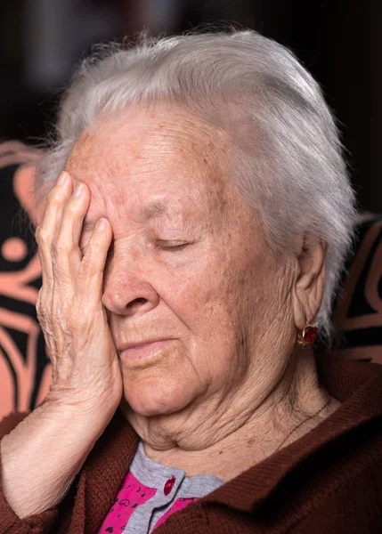 Velha mulher de cabelos grisalhos que sofre de dor de cabeça — Fotografia de Stock
