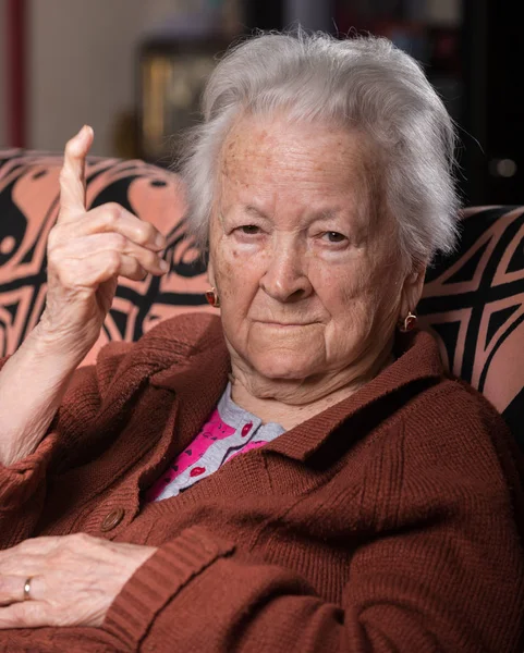 Old gray-haired woman in angry gesture — Stock Photo, Image