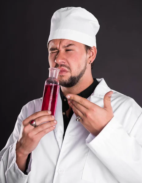 Jovem cientista barbudo em casaco uniforme branco e chapéu com — Fotografia de Stock