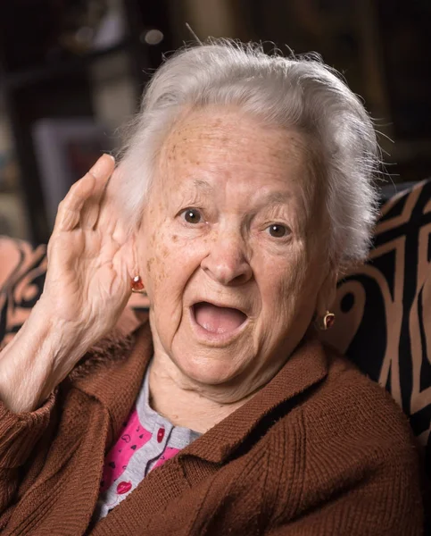 Portrait of old woman putting hand to her ear — Stock Photo, Image