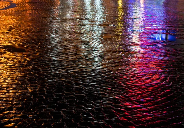 Straten na regen met reflecties van licht op natte rijweg — Stockfoto