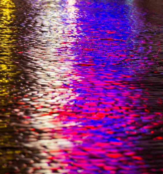 Streets after rain with reflections of light on wet roadway