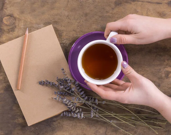 女性の手、ラベンダー、鉛筆とノートのお茶 — ストック写真