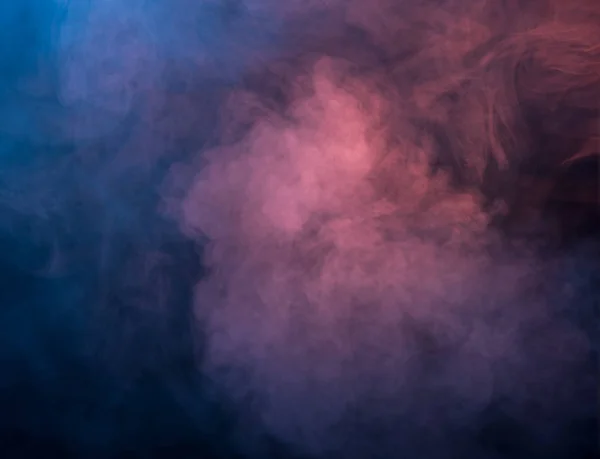 Humo azul y rosa abstracto sobre un fondo oscuro — Foto de Stock
