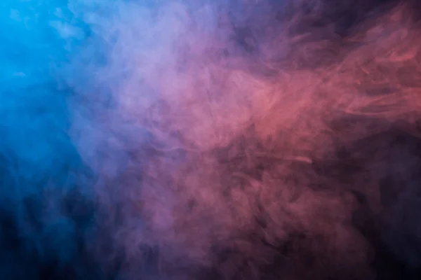 Humo azul y rosa abstracto sobre un fondo oscuro — Foto de Stock