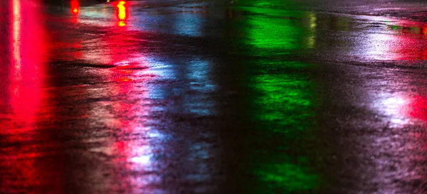 Streets after rain with reflections of light on wet roadway