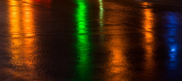 Calles después de la lluvia con reflejos de luz en la carretera mojada — Foto de Stock