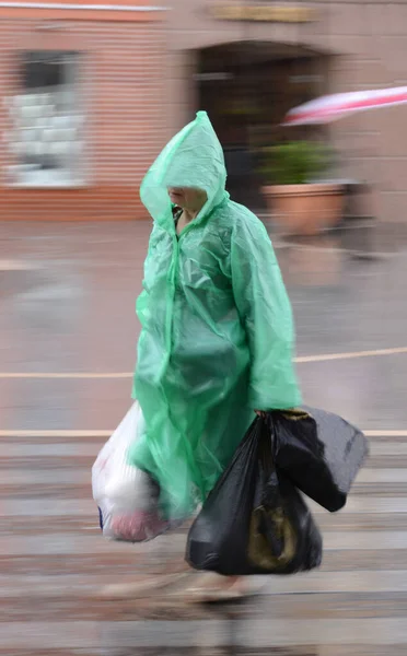 Mensen in regenjas die op regenachtige dagen door de straat lopen. Intenti — Stockfoto