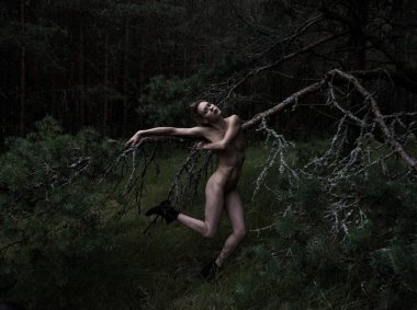 Açık havada poz veren genç çıplak bir kadının romantik görüntüsü.