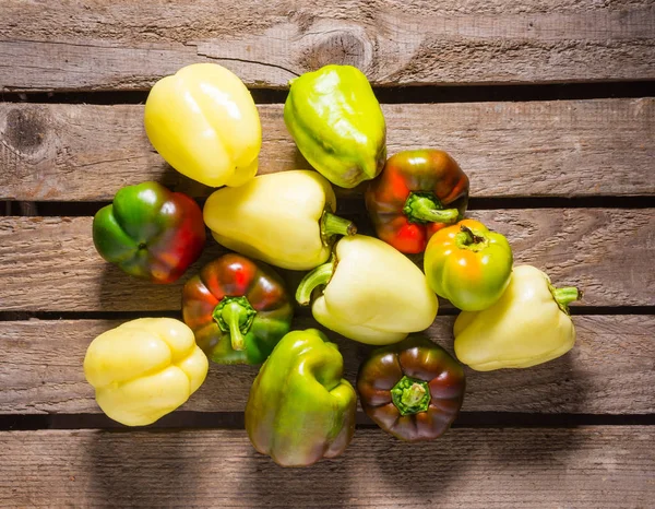 Colorful fresh organic peppers on wooden table — Stock Photo, Image