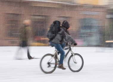 Bisikletçi şehir karayolunda hareket üzerinde bulanıklık. Karlı kış günü