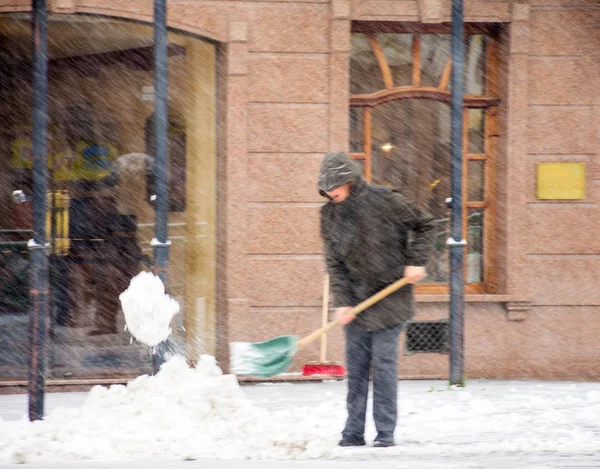 Mann schaufelt Winterschnee in der Straße — Stockfoto