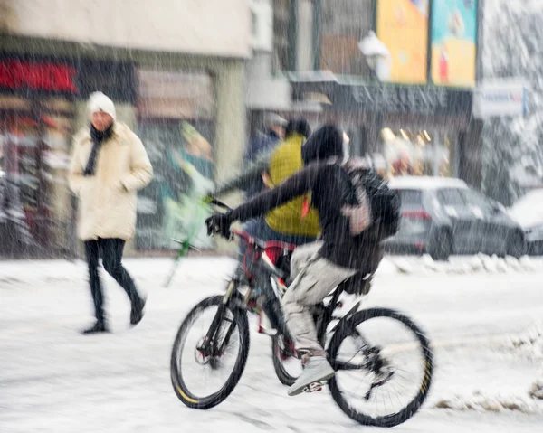 Fietser op de rijbaan van de stad in beweging vervagen. Besneeuwde winterdag — Stockfoto