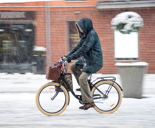 Cyclist on the city roadway in motion blur. Winter snowy day — Stock Photo, Image