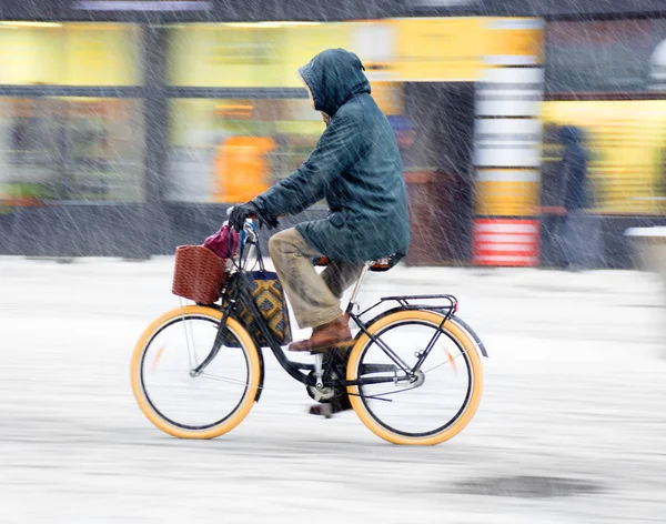Велосипедист на городской дороге в движении размыт. Зимний снежный день — стоковое фото
