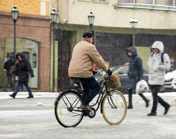 Cyclist on the city roadway in motion blur. Winter snowy day — Stock Photo, Image