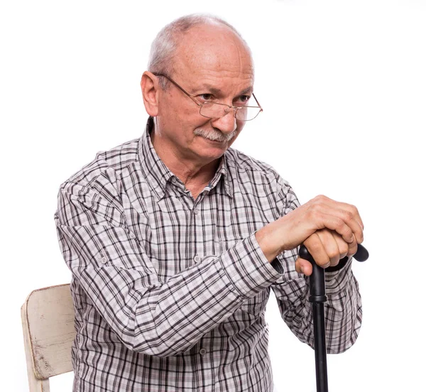 Улыбающийся пожилой человек в очках с тростью на стуле — стоковое фото