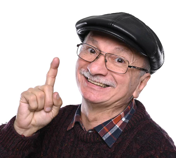 Usmívající se starší muž v klobouku a brýlích ukazuje prstem nahoru — Stock fotografie