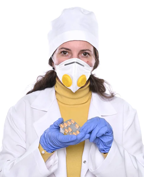 Doctora en máscara sosteniendo pastillas en las manos sobre fondo blanco —  Fotos de Stock
