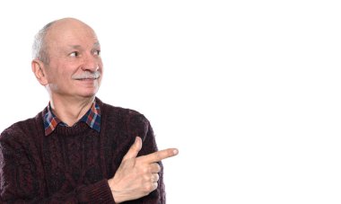 Gülümseyen kıdemli adam parmağını yana doğru gösteriyor. 