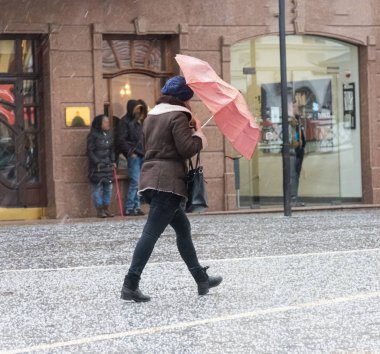 Yoğun şehir insanları kışın karlı bir günde cadde boyunca yürüyorlar.