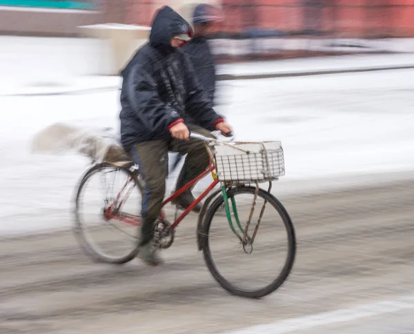 Mann mit Fahrrad in der Stadt an einem verschneiten Wintertag — Stockfoto