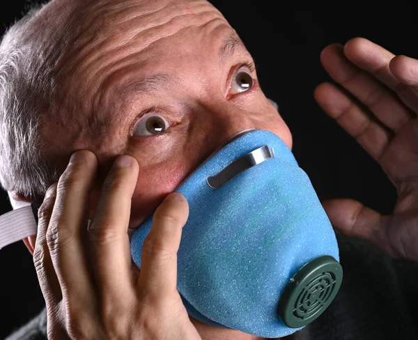Nemocný starý muž pózuje v masce s přes černé pozadí — Stock fotografie