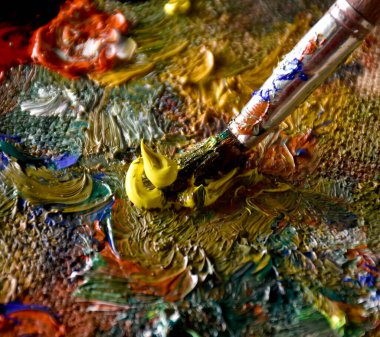 Renkli yağlı boyayı palette karıştıran sanatçı. Boya fırçalı palet. Sanat paleti