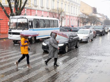 Yağmurlu bir günde, şehir sokaklarında gezen zebralı insanlar. Tehlikeli bir durum. Odaklanmamış resim. Kasıtlı hareket bulanıklığı