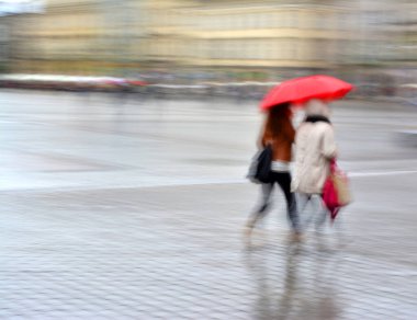 Şehir halkı cadde boyunca gidiyor. Kasıtlı hareket bulanıklığı. Odaklanmamış resim