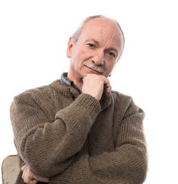 Stüdyoda beyaz arka planda poz veren yaşlı bir adamın portresi.