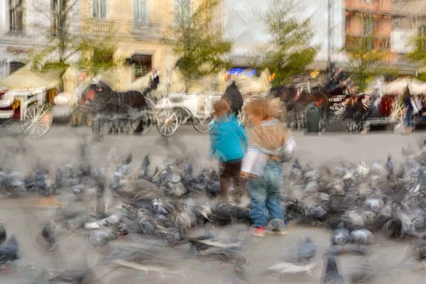 孩子们在城市街道上与鸽子玩耍 故意的动作模糊了 失真图像 — 图库照片