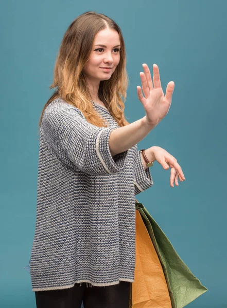 青色の背景に買い物袋を持つ幸せな女 — ストック写真
