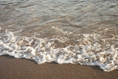 Sahilde kabarcıklarla deniz suyu dalgalarını kapatın.