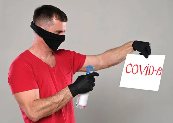 医療と医療の概念 男でマスクと手袋保持消毒剤とバナーで碑文Covid 19上の灰色の背景 — ストック写真