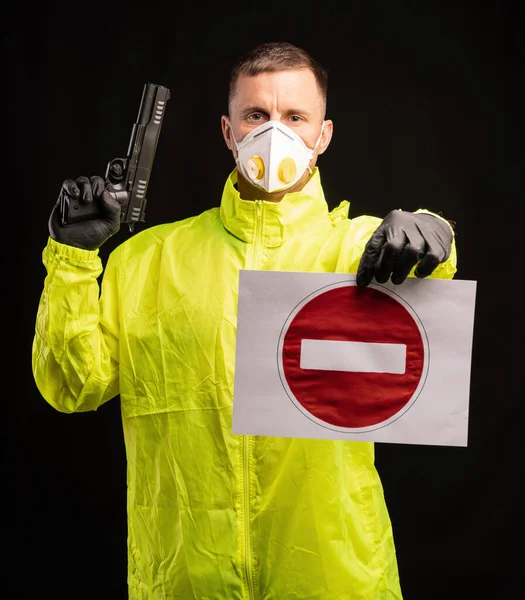 Covid 19コロナウイルス感染の概念 防護マスクの男と銃を持っている手袋黒の背景の上に署名を停止 — ストック写真