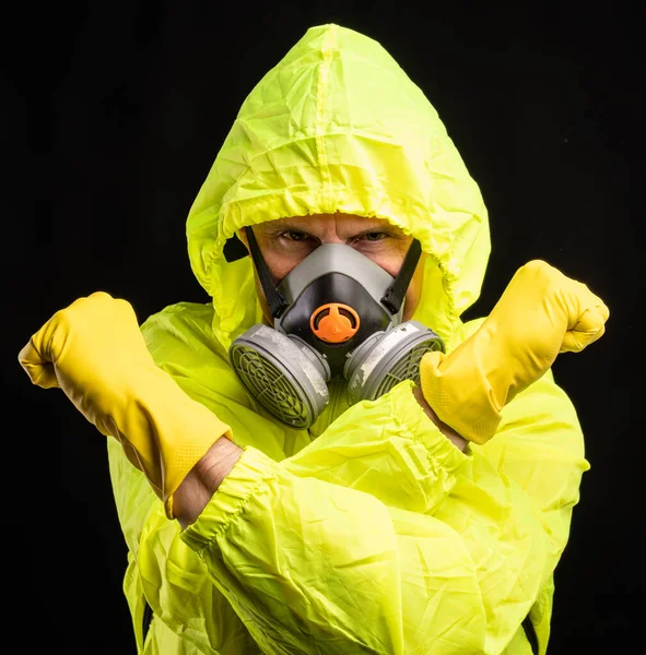 Coronavirus and healthcare concept. Respiratory protection. Portrait of young man in respirator and gloves over black background