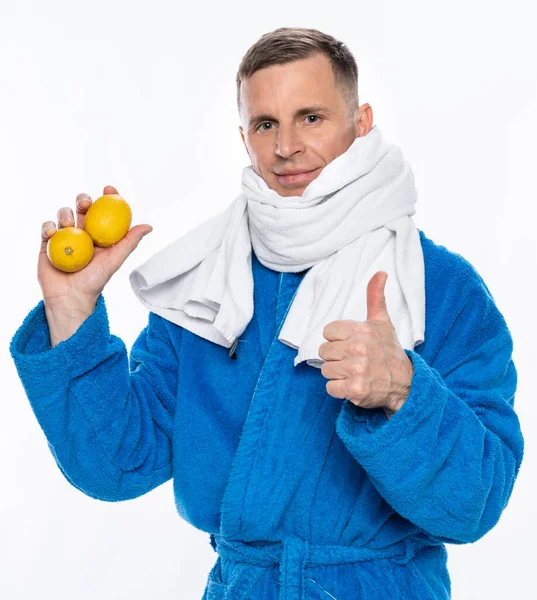 免疫と医療の概念を高める 白い背景にレモンを持つタオルに包まれたバスローブの病気の男 — ストック写真