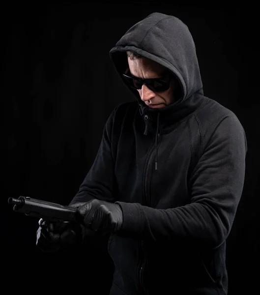 Homme Capuche Noir Avec Pistolet Posant Sur Fond Noir — Photo