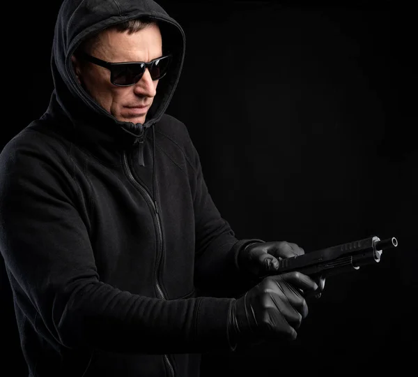 Mann Schwarzem Kapuzenpulli Mit Pistole Posiert Vor Schwarzem Hintergrund — Stockfoto
