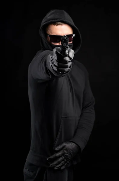 Muž Černé Mikině Pistolí Pózující Černém Pozadí — Stock fotografie