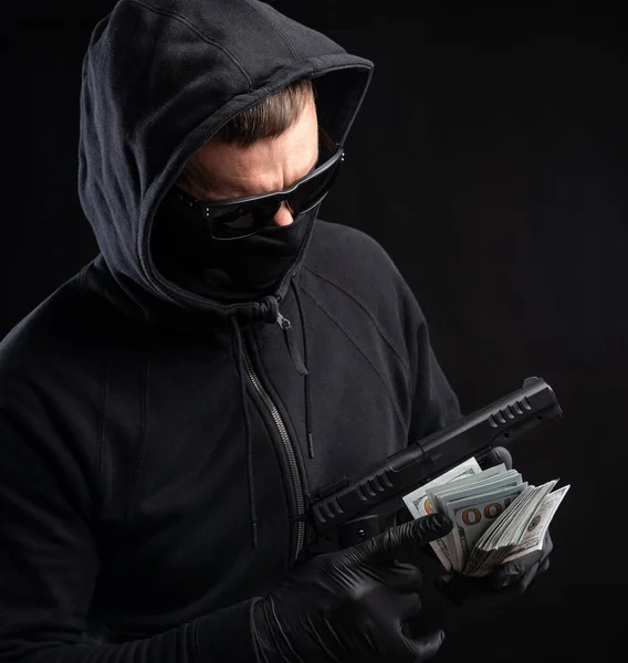 Man Black Mask Hoody Gun Pack Dollars Black Background — Stock Photo, Image