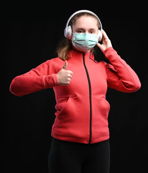 流行性コロナウイルスの概念 ティーン女の子で保護滅菌医療マスクオン彼女の顔Posing上の黒背景 — ストック写真