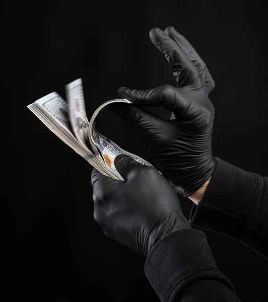 財務の概念 黒手袋の男黒の背景にドルのパックを保持 — ストック写真