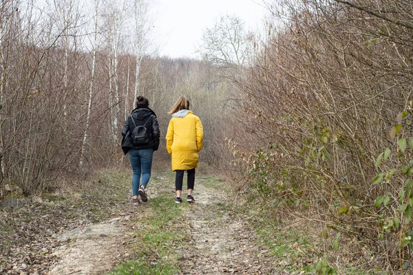 两个女孩在秋天的森林里散步 — 图库照片