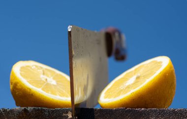 Tahtada iki dilim limon ve bıçak. Dilimlenmiş limon