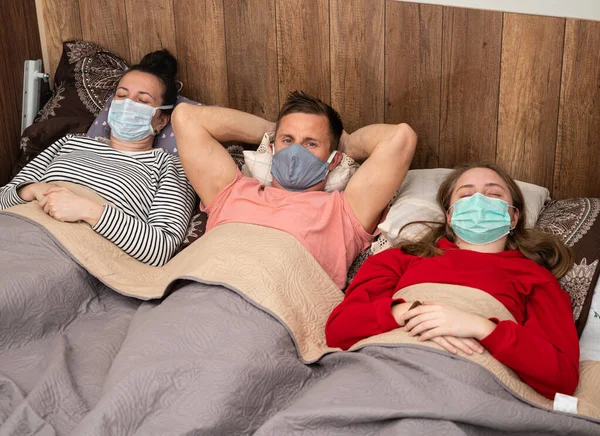 Conceito Saúde Família Doente Máscaras Protetoras Deitada Cama Casa — Fotografia de Stock